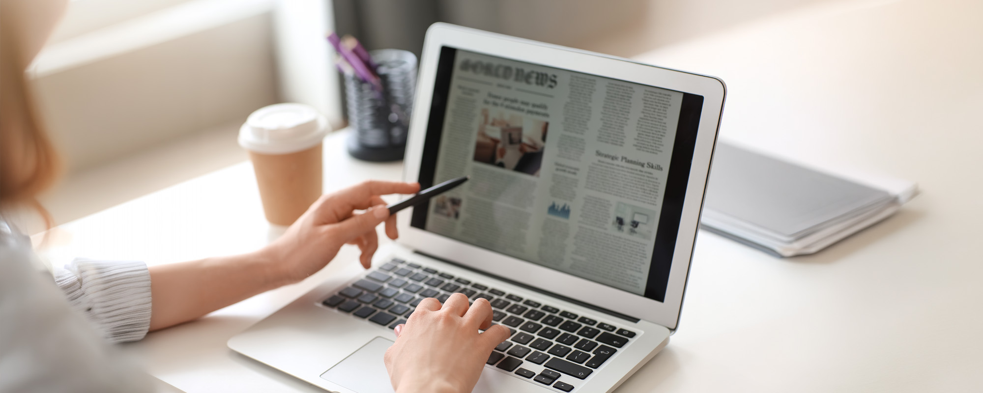 Young woman reading newspaper online at home